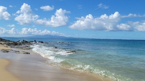 A beach with clear blue water, a sandy shore, and rocky outcrops. - Tiny house on an acre with ocean view and private infinity pool.  (Vieques)