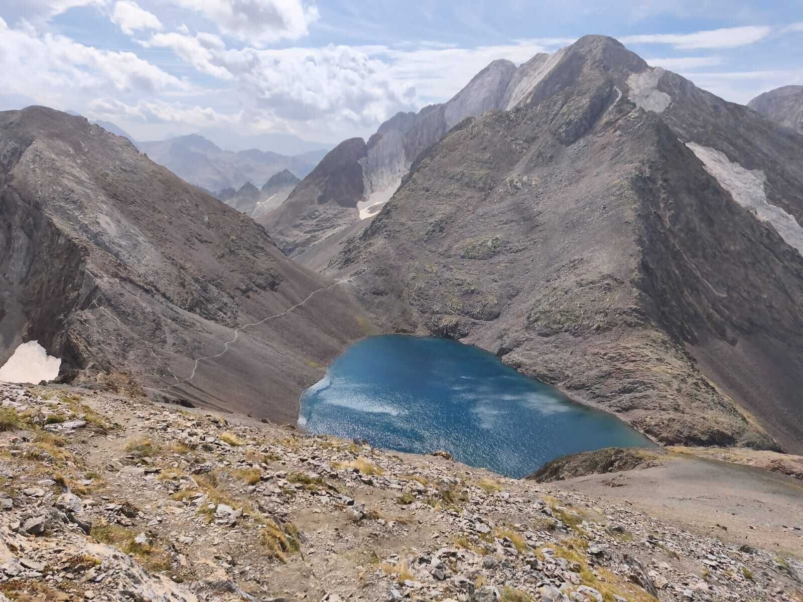 A mountainous landscape with a clear blue lake surrounded by rugged terrain.
