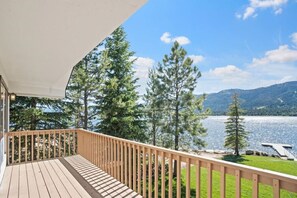 A wooden deck with a view of a lake and mountains.