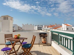 Enjoy al fresco dining on the rooftop with a grill and seating for a relaxing meal.