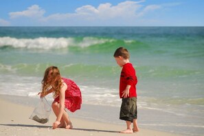 A beach scene with a child and an adult.