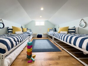 A room with two beds, a small window, and a stack of colorful blocks.