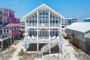 A two-story beach house with a balcony, multiple windows, and a flag. - Oceanfront/Zero Steps to Beach/Views/4BR (Gulf Shores)