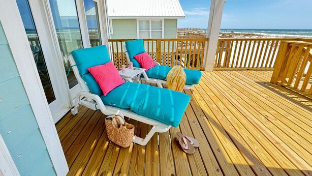 A wooden deck with two lounge chairs, each with a blue cushion and a pink pillow. - Oceanfront/Zero Steps to Beach/Views/4BR (Gulf Shores)