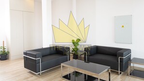 A modern hotel lobby with a dark gray sectional sofa, a glass coffee table, and a potted plant. - The Crown Hotel Klia (Sepang)