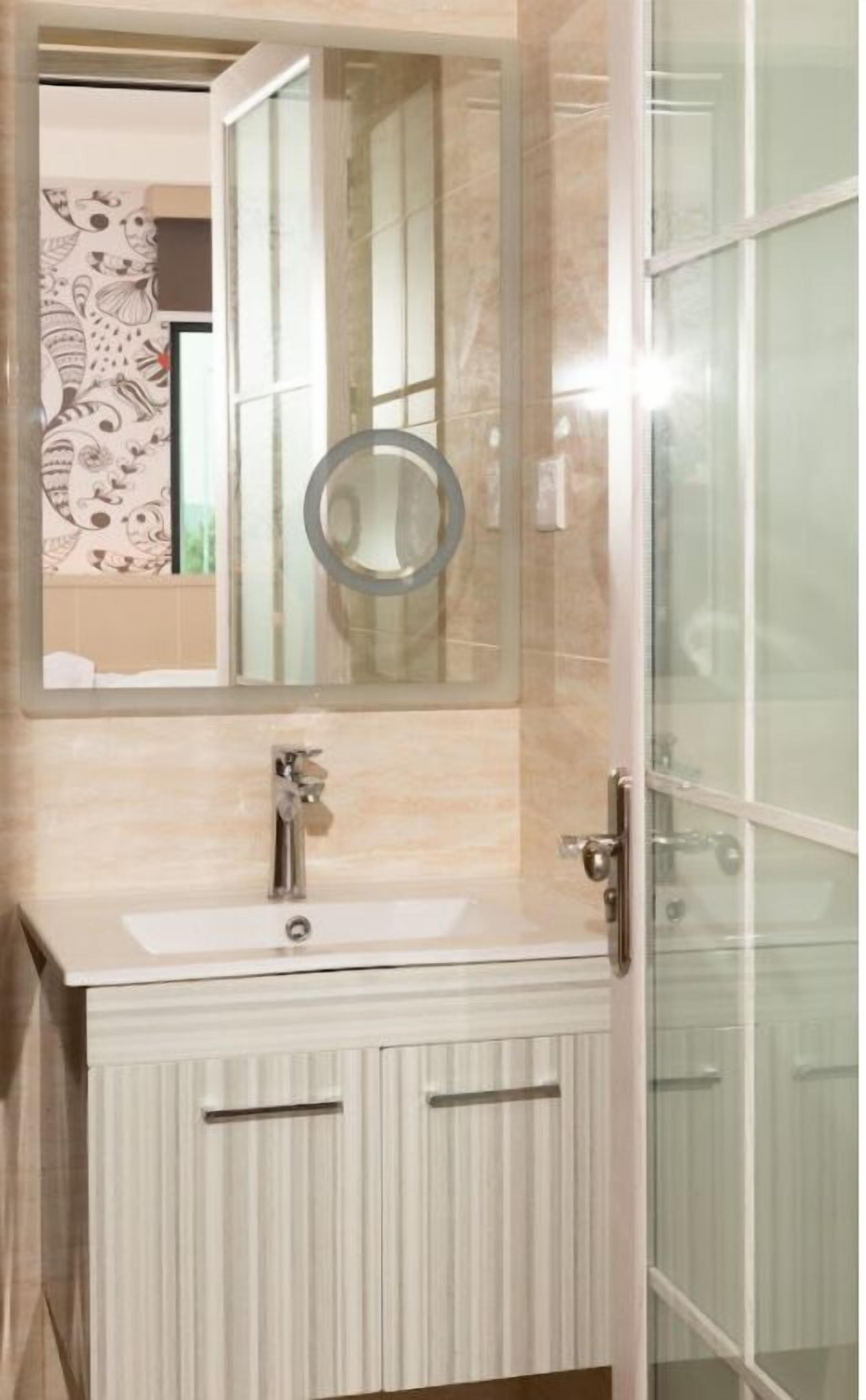 Un baño con un espejo grande, un lavamanos y una cabina de ducha de vidrio.