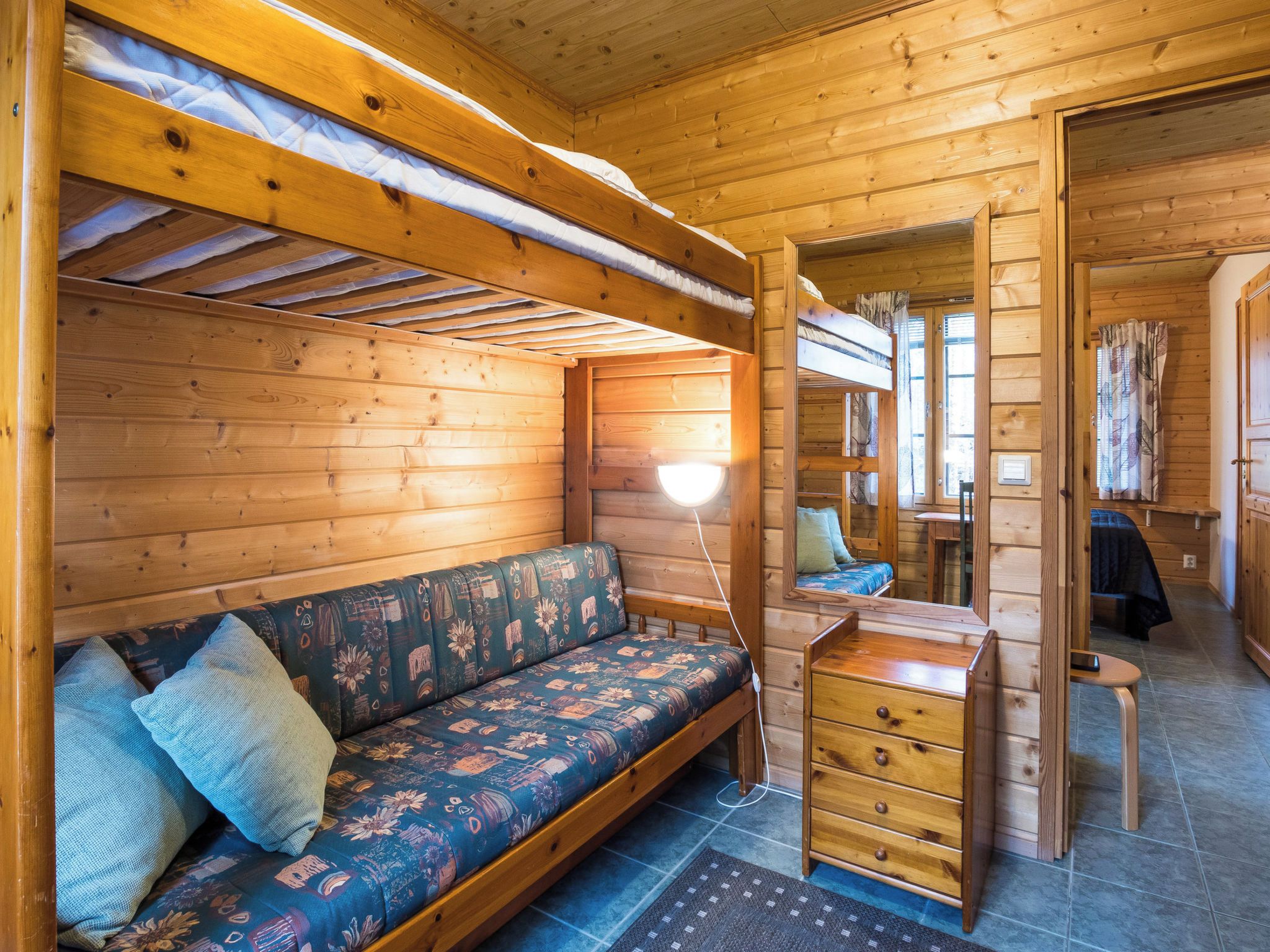 A cozy cabin interior with a wooden bench, a desk, and a small table.