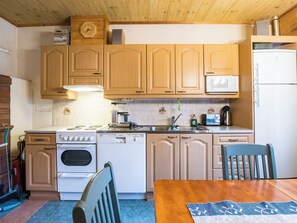 Une cuisine avec des meubles de rangement en bois, une cuisinière, un four à micro-ondes et un réfrigérateur.
