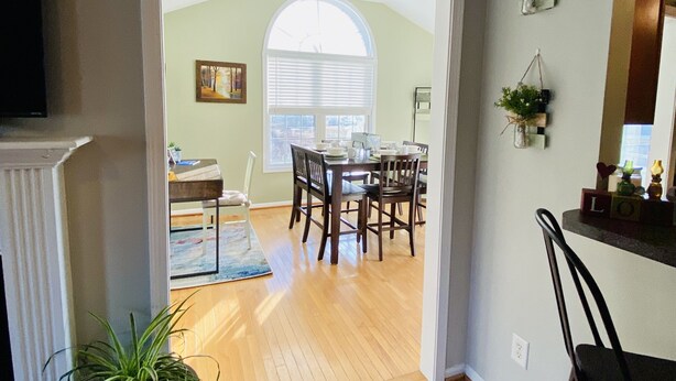 A dining area with a wooden table and chairs, a potted plant, and a view through an arched doorway to another room. - **cozy country** *stargazing acre* (Franklinton)