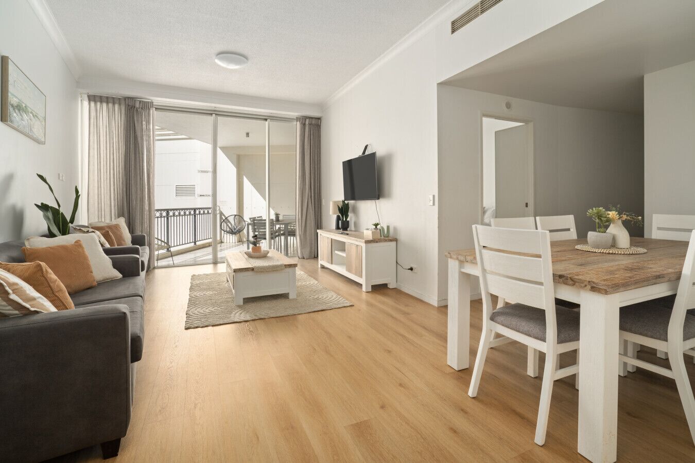 Un salon moderne comprenant un canapé, une table basse et un coin repas avec des chaises et une table.