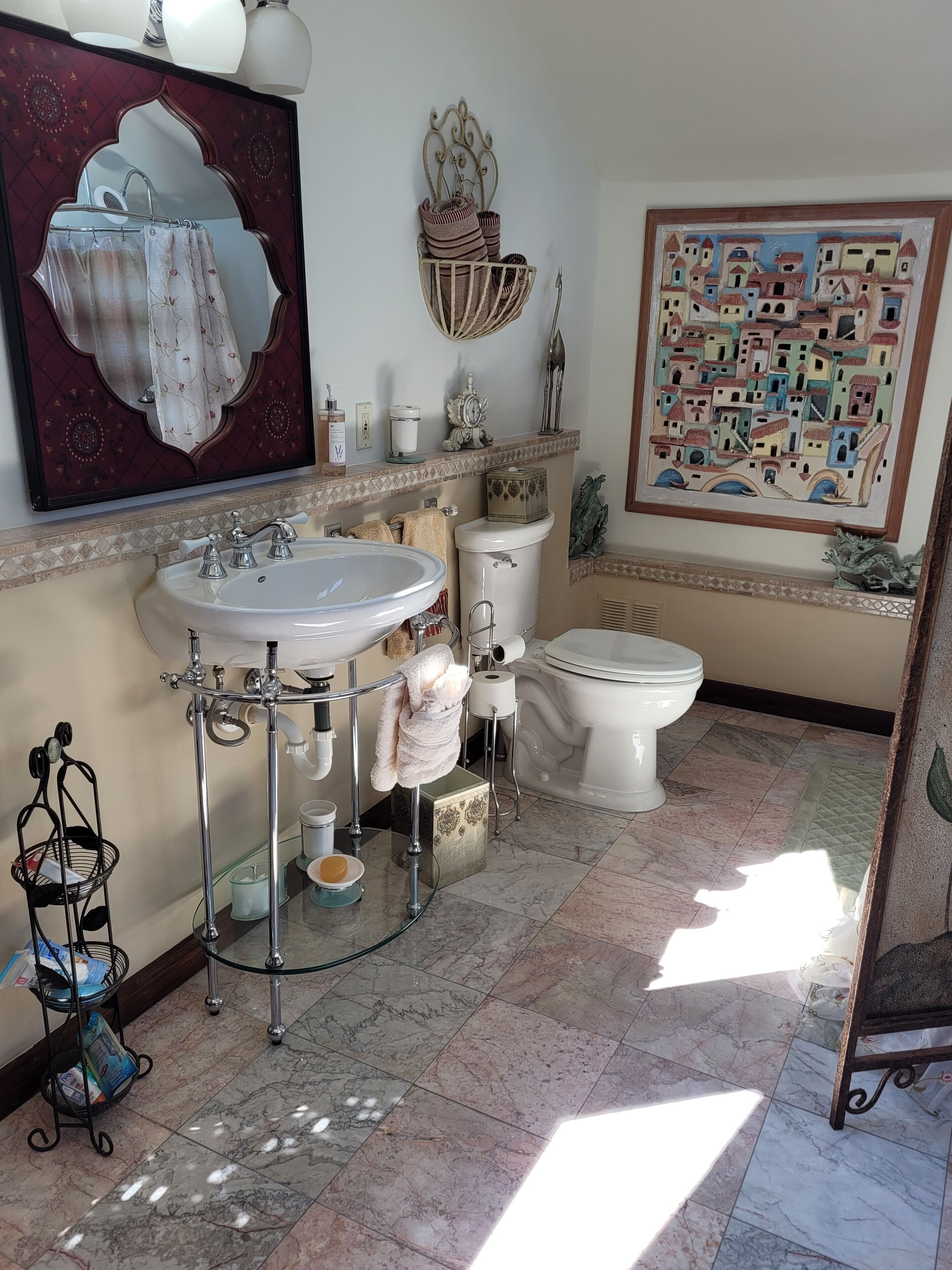 A bathroom with a large mirror, a sink, a toilet, and a shower area.