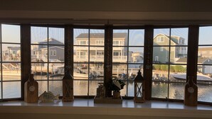 Una finestra a bovindo con vista su un porto turistico e palazzi residenziali.
