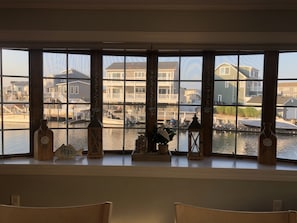 Un ventanal con vistas a un puerto deportivo y edificios residenciales.