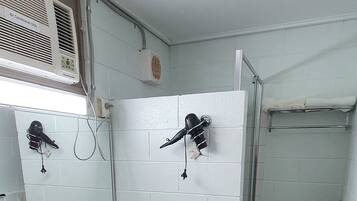 A bathroom with two sinks, a mirror, a towel rack, and a shower area.