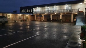 A building with a covered parking area, multiple entrances, and a staircase leading to an upper level. - Morwell Parkside Motel (Morwell)