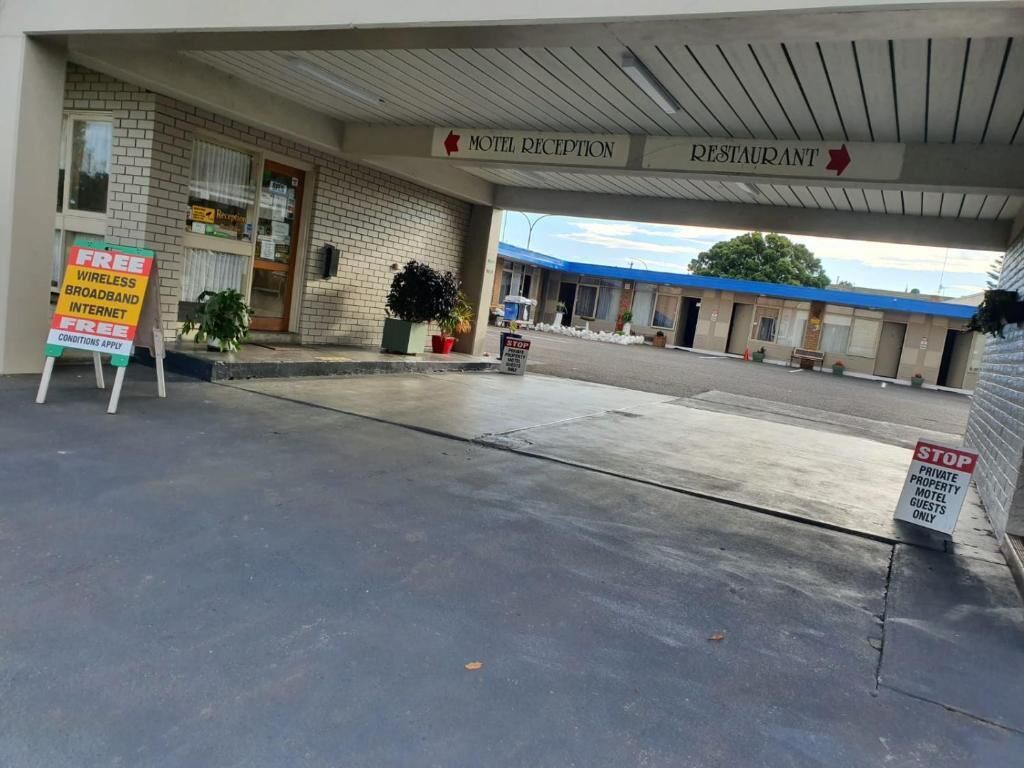 A motel reception and restaurant area with a sign offering free wireless broadband internet.