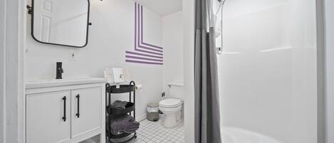A modern bathroom with a white sink, mirror, and toilet.