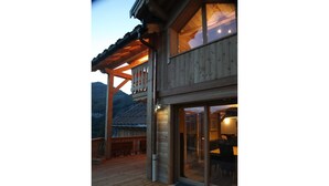 Ein Holzhaus mit Balkon und großen Fenstern.