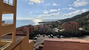 Zona residencial a la costa, amb edificis, un aparcament i vistes al mar.