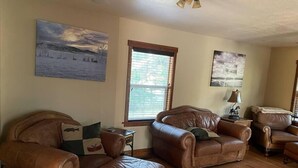 A living room with leather sofas, a wooden coffee table, and a window with blinds. - CUTE COTTAGE WITH A GAME ROOM (Belgrade)