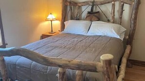 A bed with a rustic wooden headboard and a simple bedside lamp. - CUTE COTTAGE WITH A GAME ROOM (Belgrade)