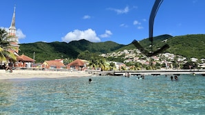 Un pueblo costero con una iglesia, playa y montañas.