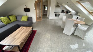 Eine moderne Wohnung mit Wohnzimmer, Essbereich und Küche.