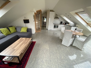Eine moderne Wohnung mit Wohnzimmer, Essbereich und Küche.