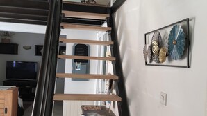 A staircase with wooden steps and a black railing, leading to a landing with a decorative wall piece. - Guest house ideally located (La Teste-de-Buch)