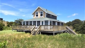 A two-story building with a flat roof and a balcony on the upper floor.