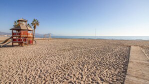 A beach with a lifeguard tower, a wooden walkway, and a clear sky. - Cozy apartment in Alicante (Alacant) with sauna (Alicante (Alacant))