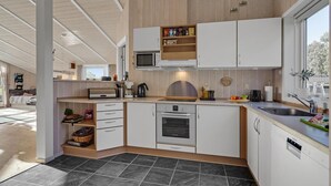 A modern kitchen with white cabinets, a built-in oven, and a microwave. - Gorgeous home in Humble with kitchen (Humble)