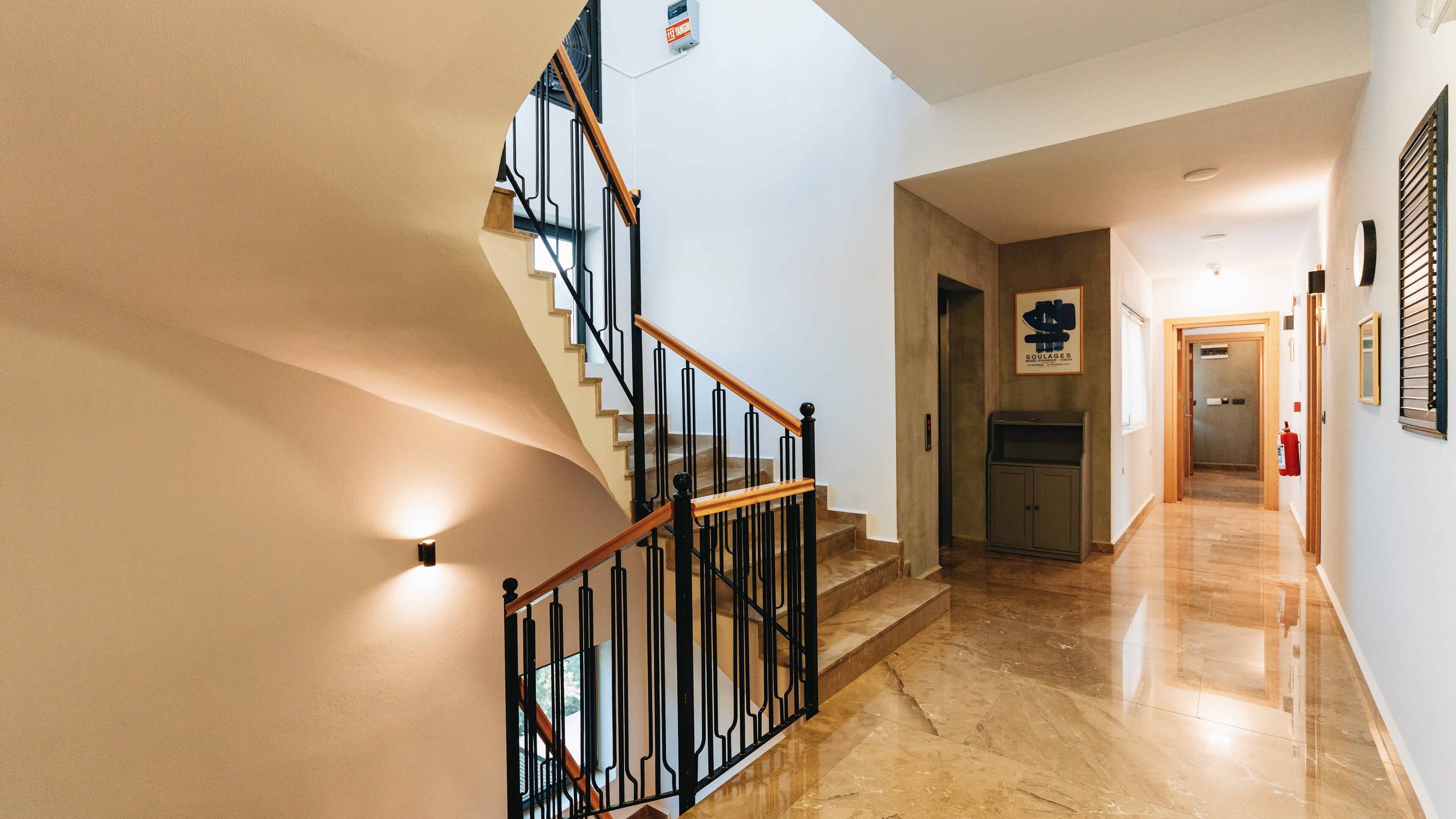 A staircase with black railings and wooden steps leading to a landing.