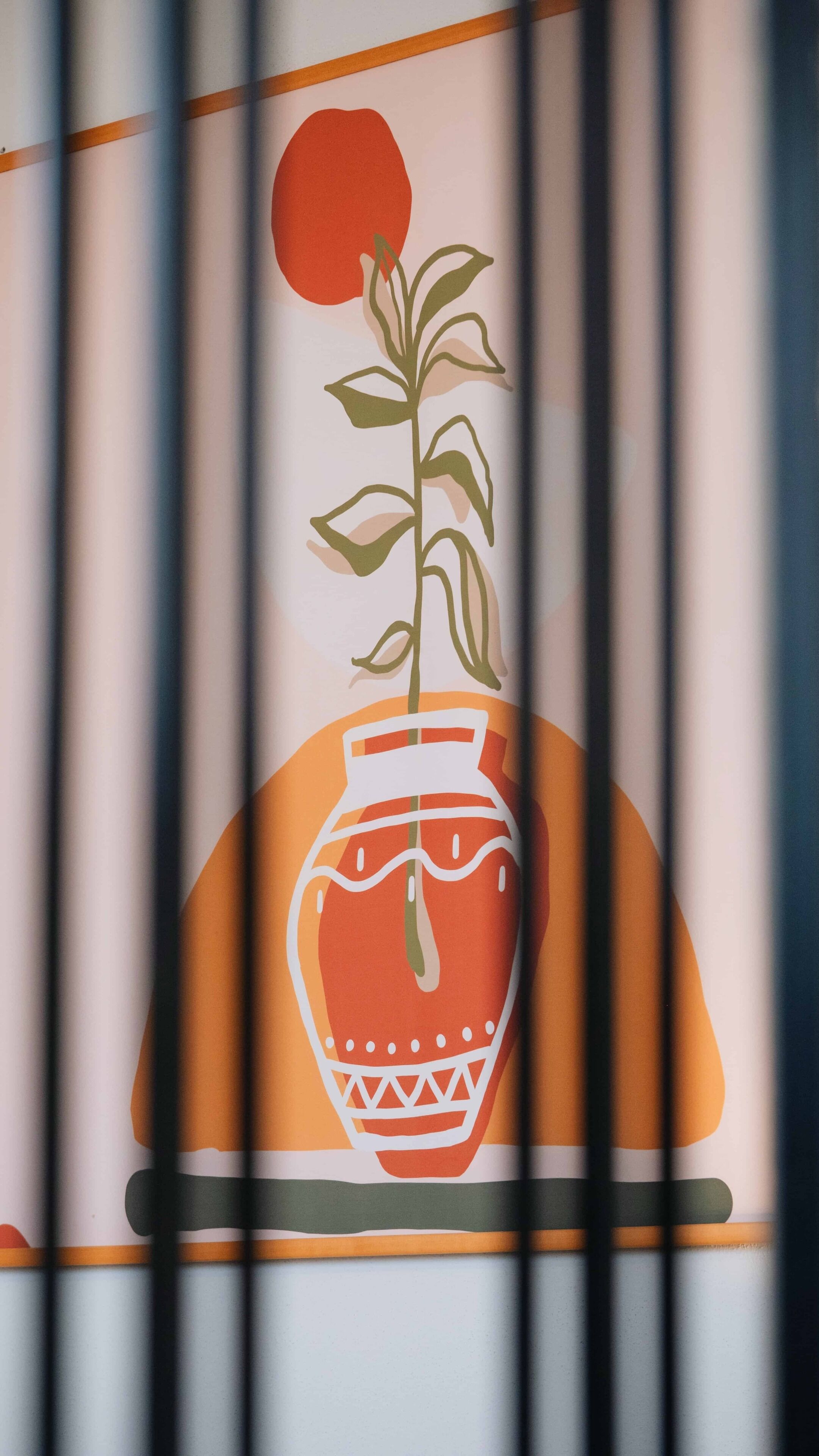 A wall with a decorative panel featuring a stylized plant in a pot.
