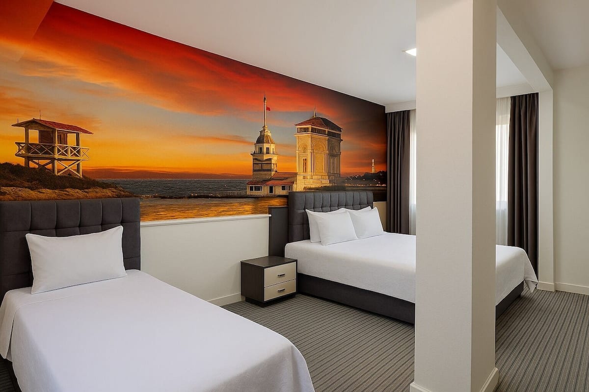 A hotel room with two beds, a nightstand, and a mural of a sunset cityscape.