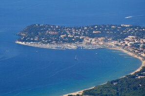 An aerial view of a coastal town with a marina, buildings, and a beach. - Studio cabin 10 minutes from the center and beaches on foot (Cavalaire-sur-Mer)