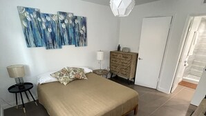 A bedroom with a large bed, a dresser, a lamp, and a painting on the wall. - Blocks Aways From Brickell Village, 2 beds 2 Baths FREE Parking NO Cleaning FEES (Miami)