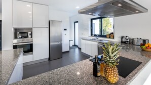 Una cucina moderna con elettrodomestici in acciaio inossidabile, piani in granito e un'ampia finestra che garantisce luce naturale.