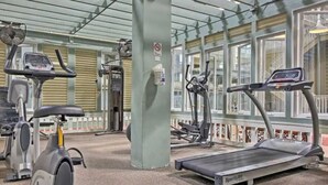 A gym with stationary bikes, a treadmill, and exercise equipment.