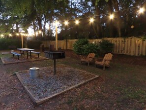 Enjoy al fresco dining and relaxation in this charming patio area with a barbecue grill, wooden table, and benches.