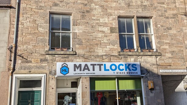 A two-story stone building with a sign for 'MattLocks Locksmith Services' on the ground floor. - Huge 4 Bed Apt - Perfect Base to Explore The Borders (Jedburgh)