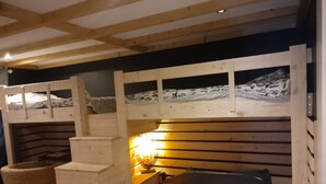 A bunk bed room with a wooden ladder and a small table with a lamp. - Warm refuge for family vacations  (Saint-Jacques-des-Blats)