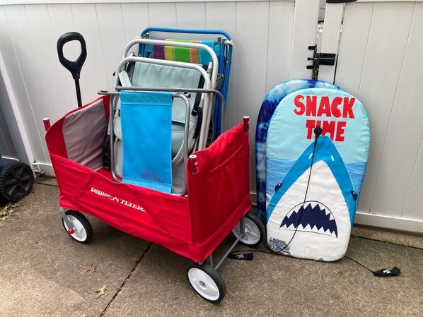 A red wagon with a blue canopy, a blue inflatable shark, and a red bag with a handle. - Beachside Cottage- 1 min walk to sand and sun (Huron)