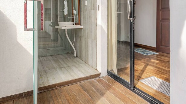 Un baño moderno con cabina de ducha de vidrio, un lavamanos y un espejo.