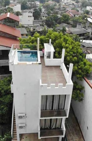 A modern building with a rooftop pool and a white exterior. - PropertyOne: Entire Home with private swimming pool and jacuzzi. (Sri Jayawardenepura Kotte)