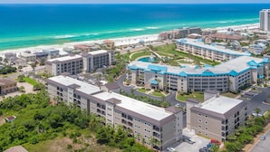 Ein Küstenhotel mit mehreren Gebäuden, einem Strand und freiem Blick auf den Ozean.