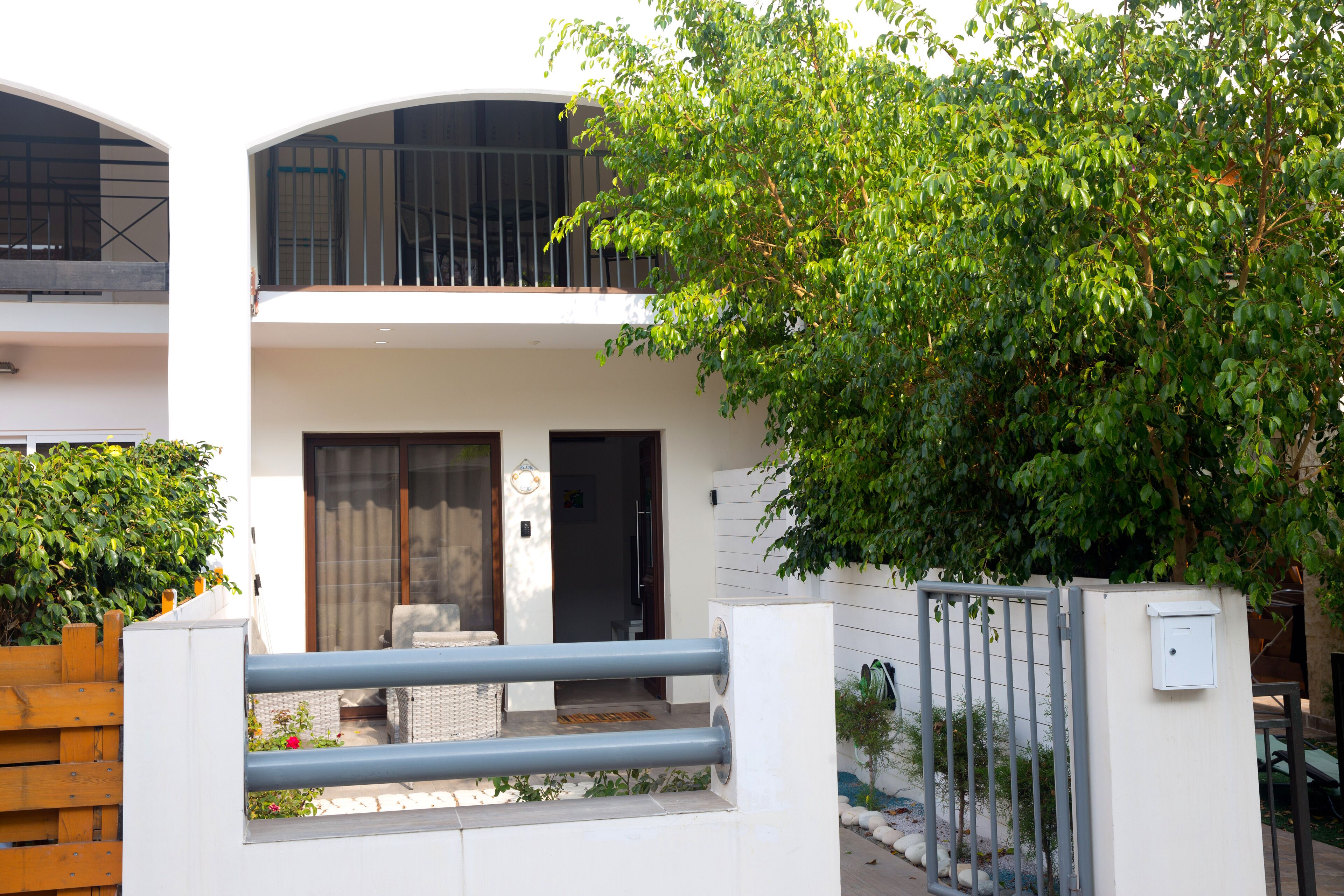 Une maison moderne à deux étages, dotée d’un balcon, d’une entrée sécurisée et d’un jardin bien entretenu.