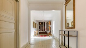 A hallway with a wooden floor, white walls, a mirror, and a console table. - Chateau / Country House (La Celle)