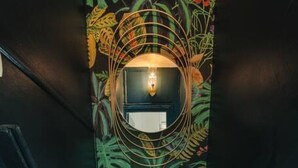 A narrow, industrial-style elevator shaft with a decorative, nature-themed mural on the walls.