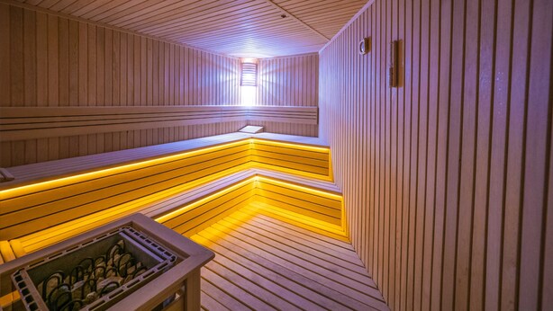 A sauna with wooden walls and benches, a sloped floor, and a skylight. - Balsoy Mountain (Erzurum)